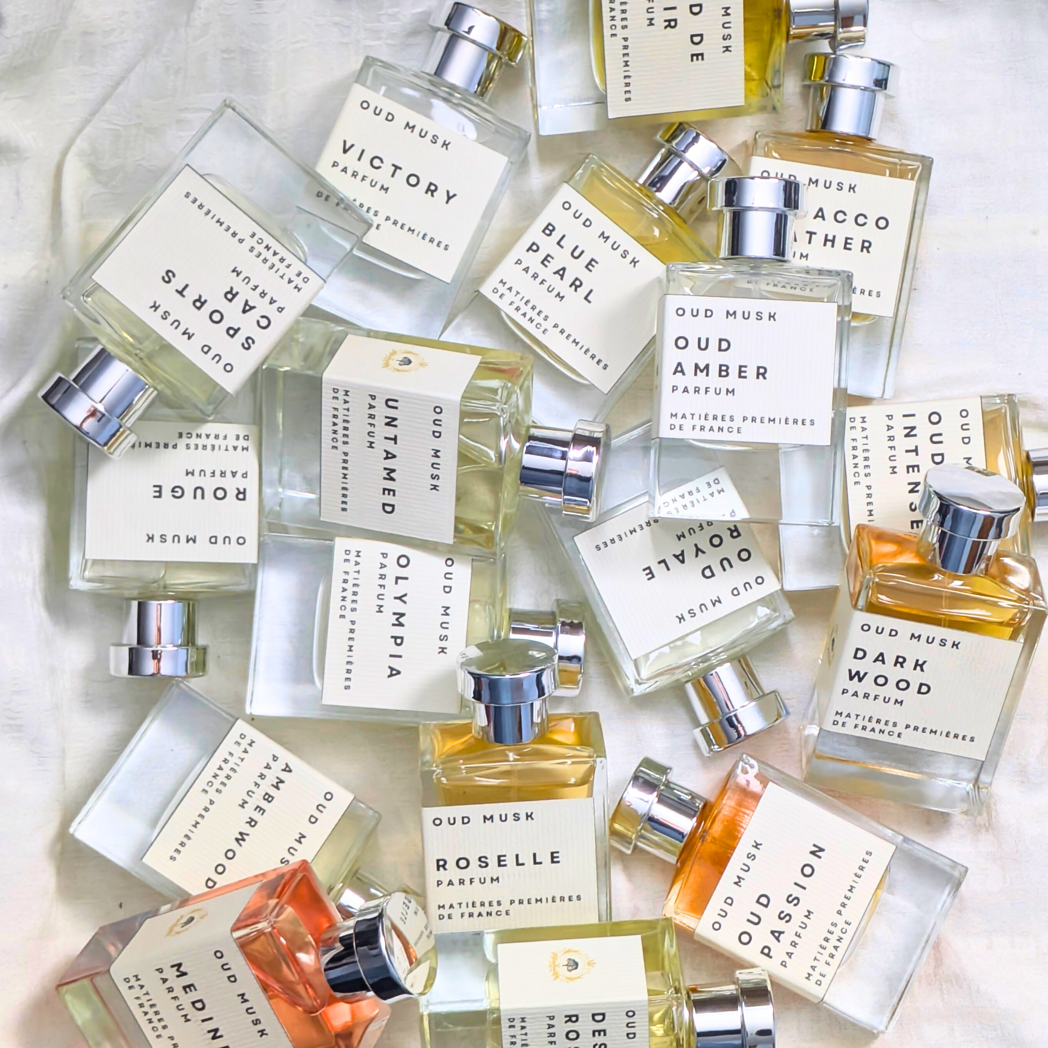 Collection of various perfume bottles with labels on a light background